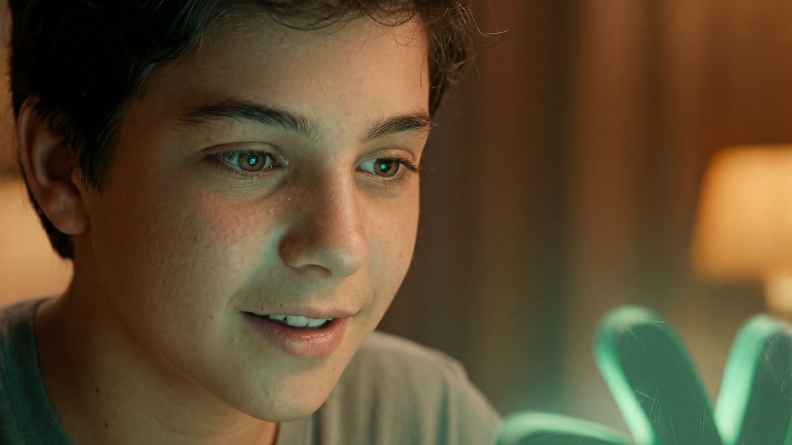 Adolescente sorrindo diante da luz do celular, descobrindo a resposta de uma dúvida